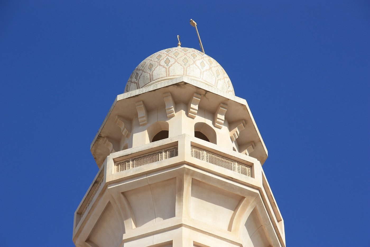 Mosque minaret against blue sky in Muscat