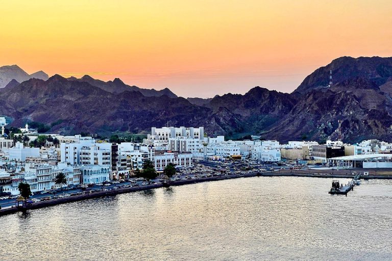 Coastal city and mountains at sunset in Oman